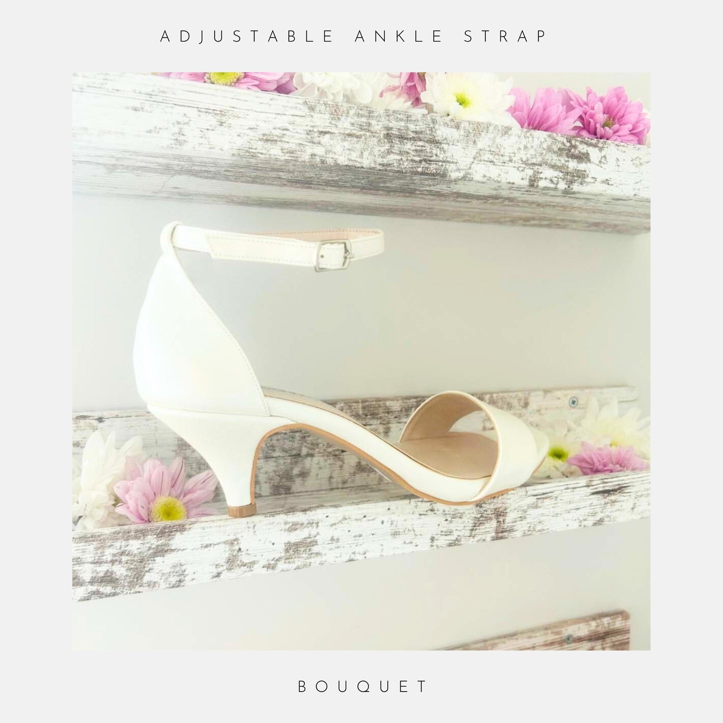 The Bouquet Kitten Heel Bridal Shoes by Phoenix England feature an ivory pearl vegan leather finish and ankle strap, displayed on a rustic white shelf among pink, white, and lavender daisies. Text reads Adjustable Ankle Strap and Bouquet.