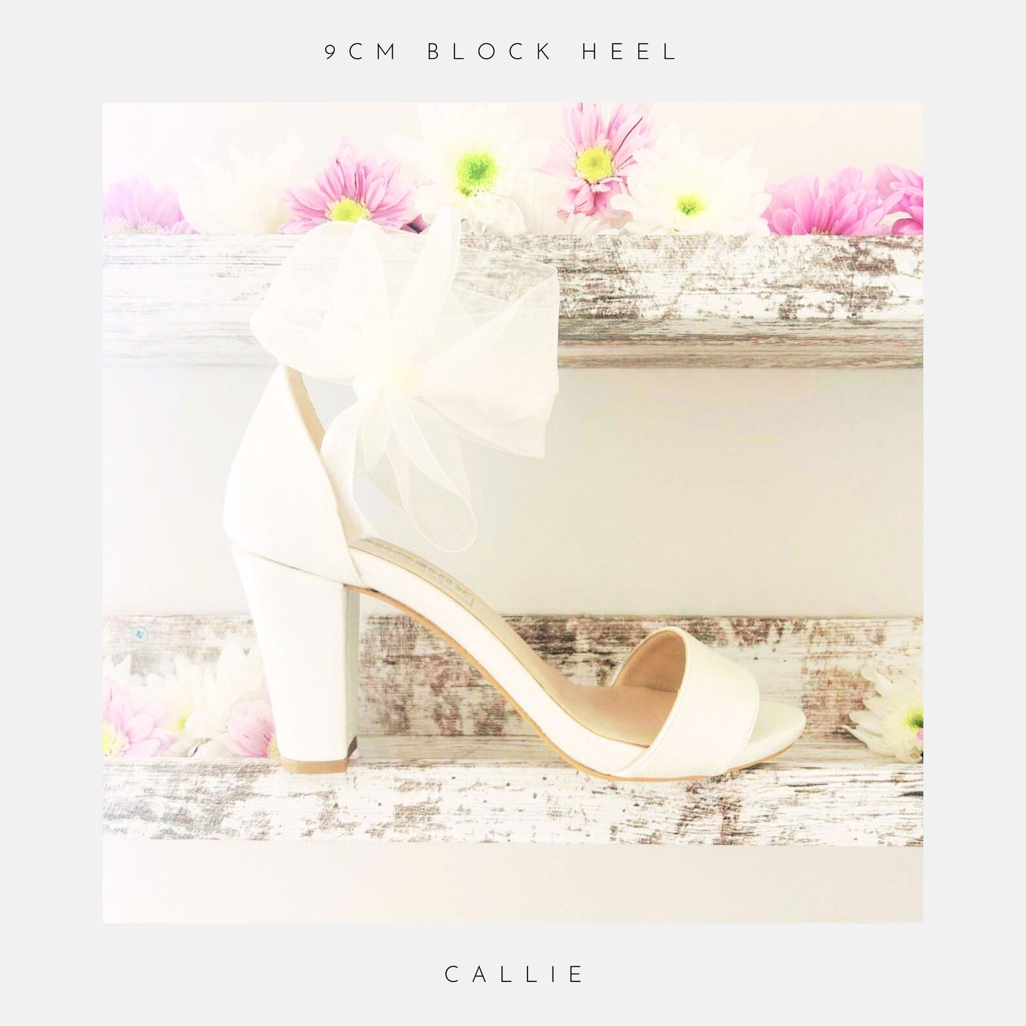 Ivory high-heeled shoe with a bow on a wooden surface with flowers, labelled '9cm block heel' and 'Callie'.