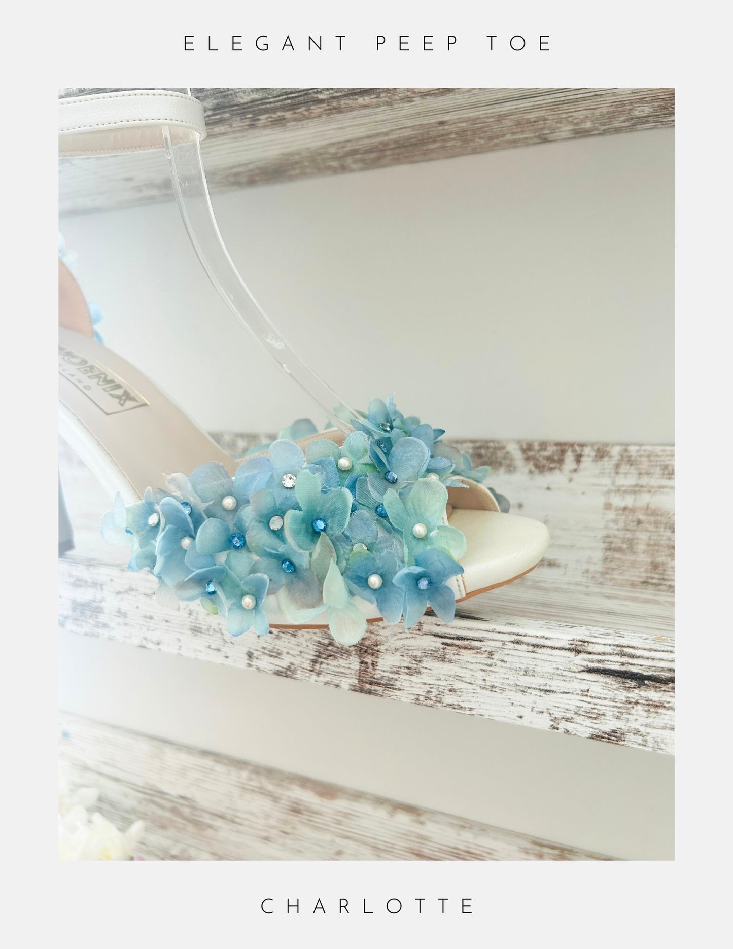 Ivory sandal with blue floral decorations on a wooden surface, labelled 'Elegant Peep Toe' and 'Charlotte'.