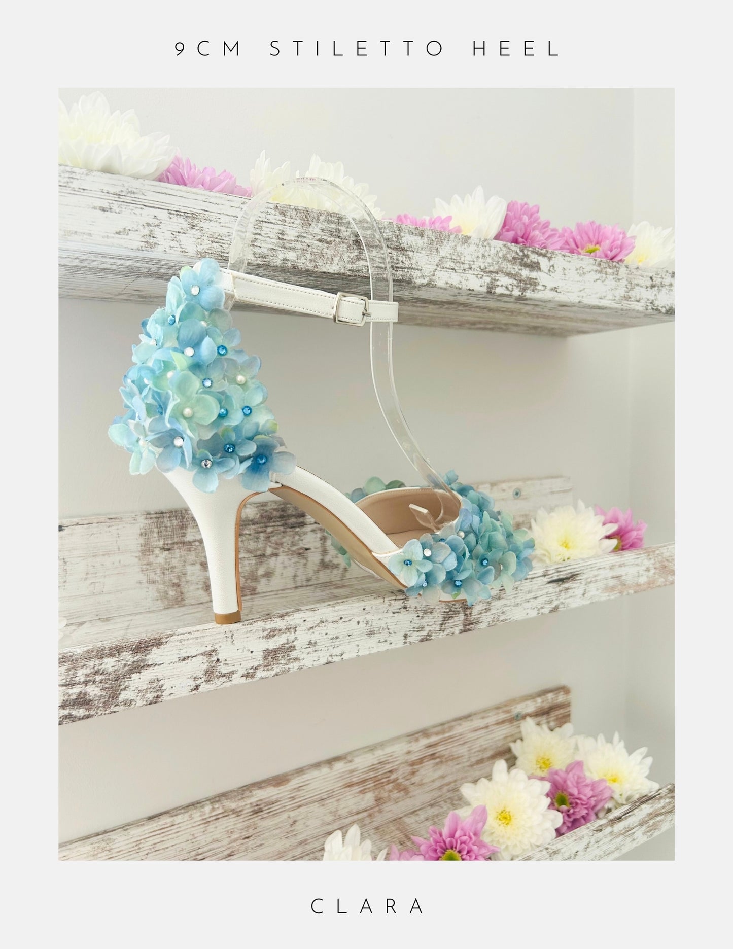 High-heeled bridal shoe with floral design on a wooden surface, featuring the brand 'Clara'.