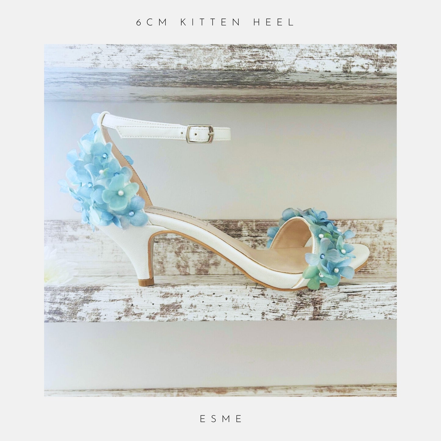 ivory kitten heel bridal shoe with floral decorations on a wooden surface, labelled 'ESME'.