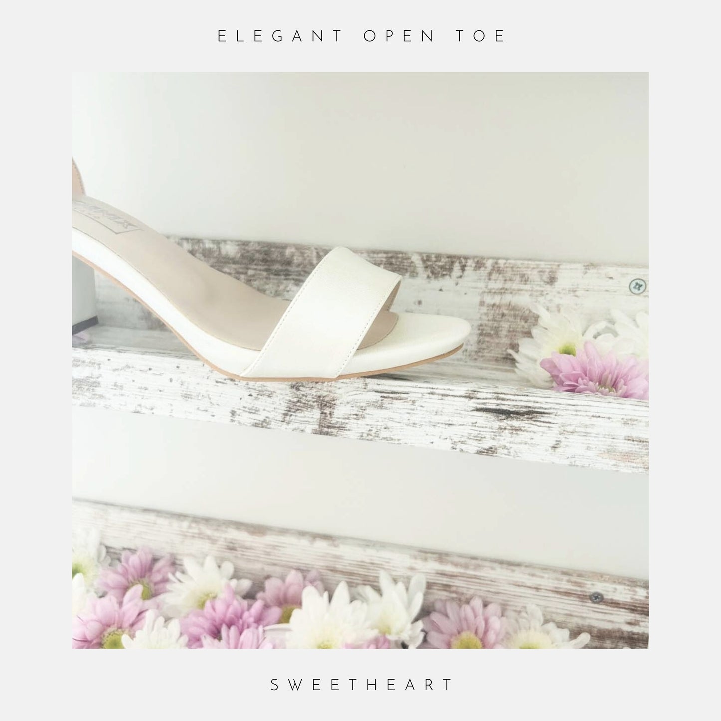 Ivory high-heeled shoe on a wooden surface with flowers, labeled 'Elegant Open Toe' and 'Sweetheart'.