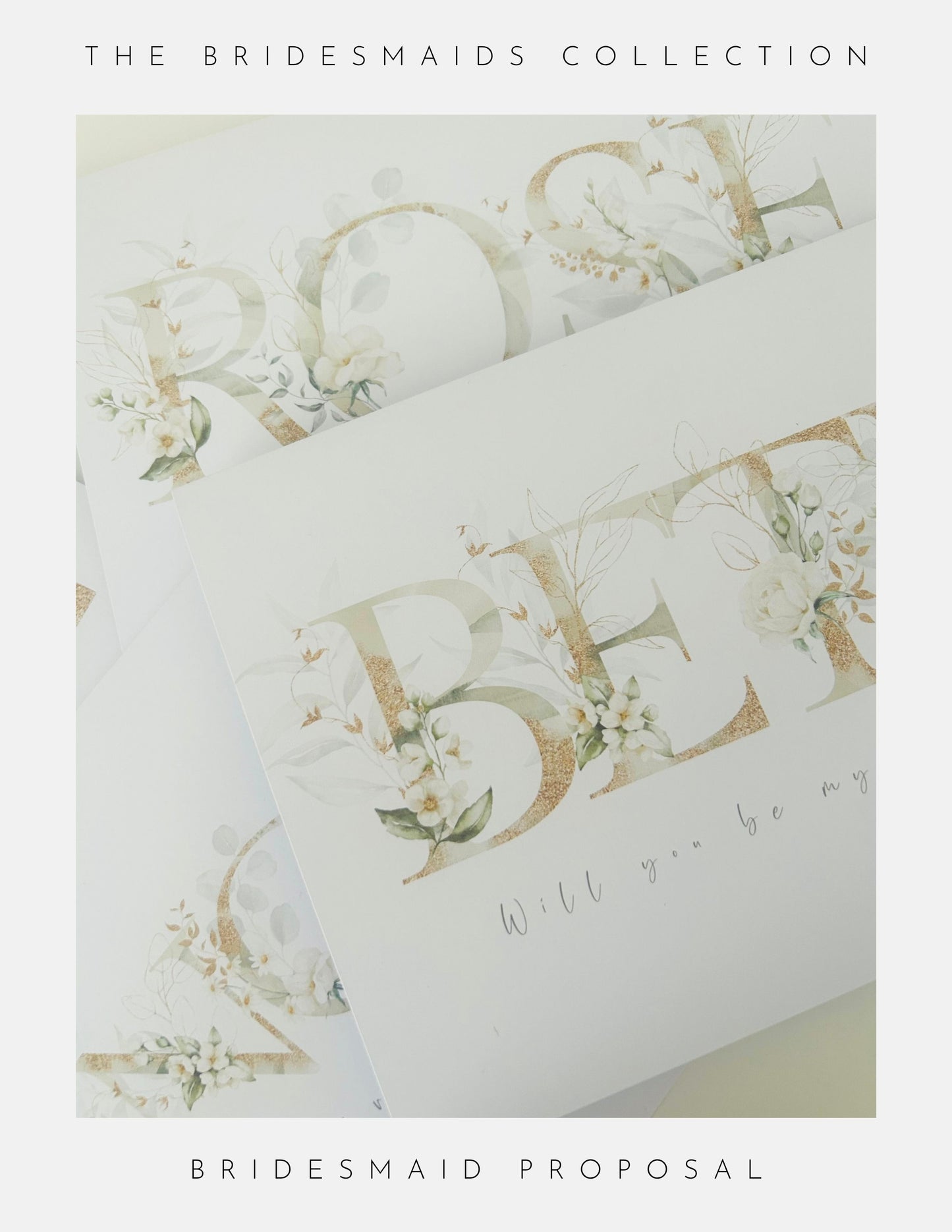 A close-up of elegant white cards with gold floral lettering from Phoenix England, titled Be My Bridesmaid Gifts, perfect for your bridesmaid proposal and part of The Bridesmaids Collection.