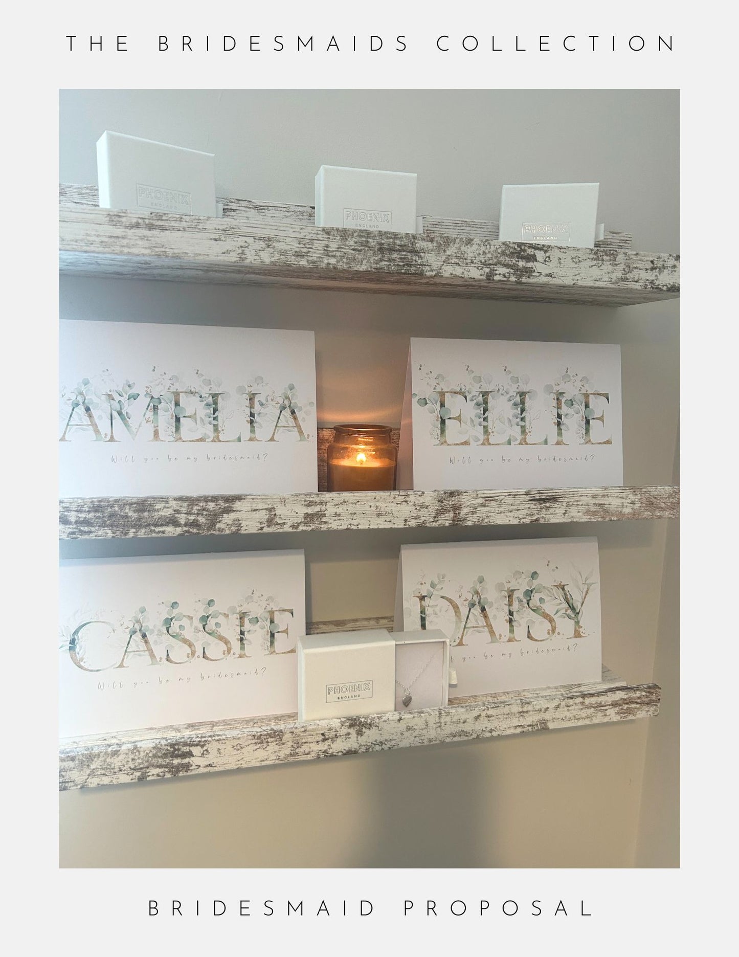 Three rustic shelves showcase Phoenix Englands Maid Of Honour Proposal Sterling Silver gift boxes—with white boxes, candles, and sterling silver jewellery—labeled AMELIA, ELLIE, CASSIE, and DAISY under “The Bridesmaids Collection.”.