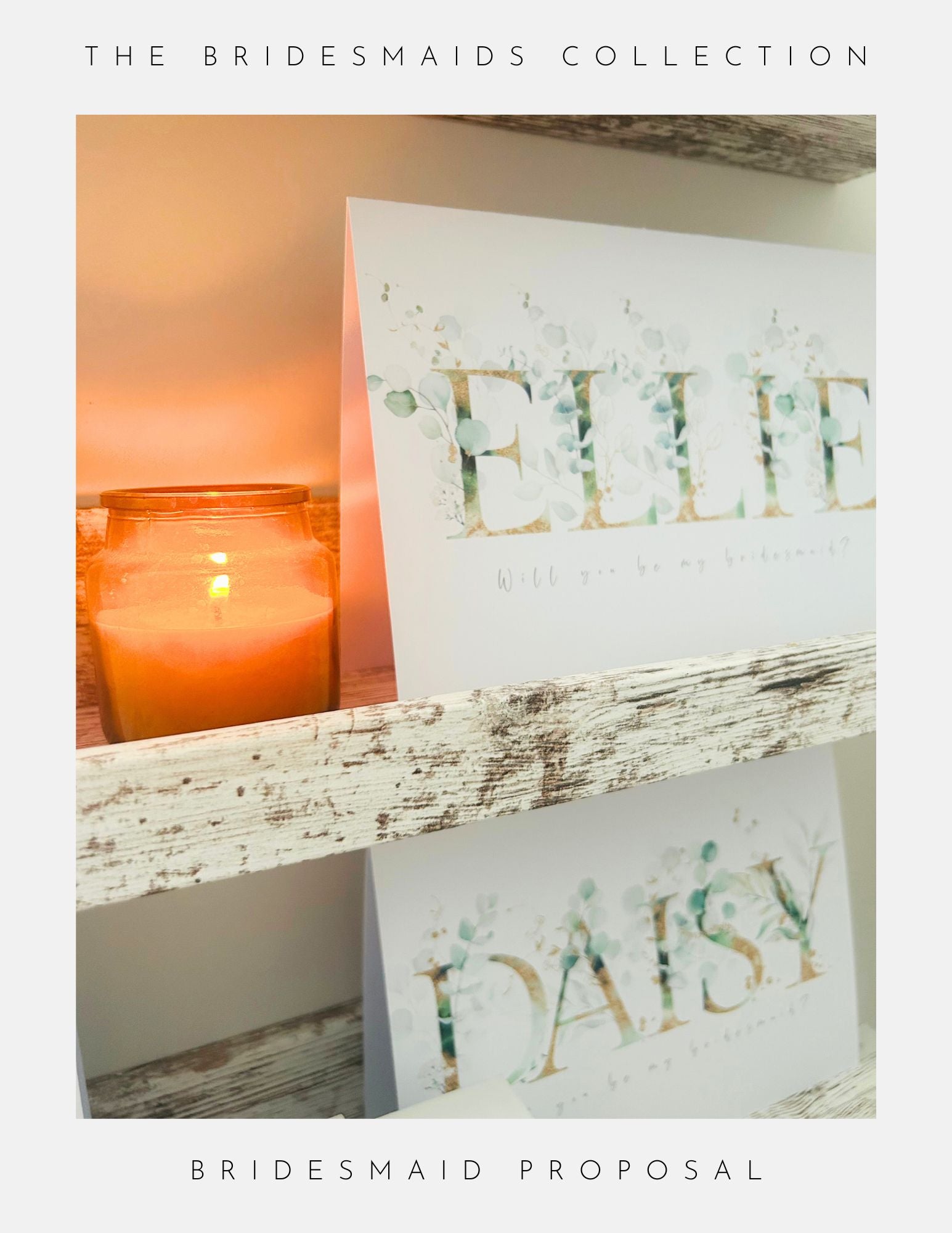 A lit candle rests on a rustic shelf beside elegant floral cards, with large letters spelling ELLIE and DAISY. The Bridesmaids Collection features Phoenix Englands Maid Of Honour Proposal Sterling Silver, perfect for your bridesmaid proposal.