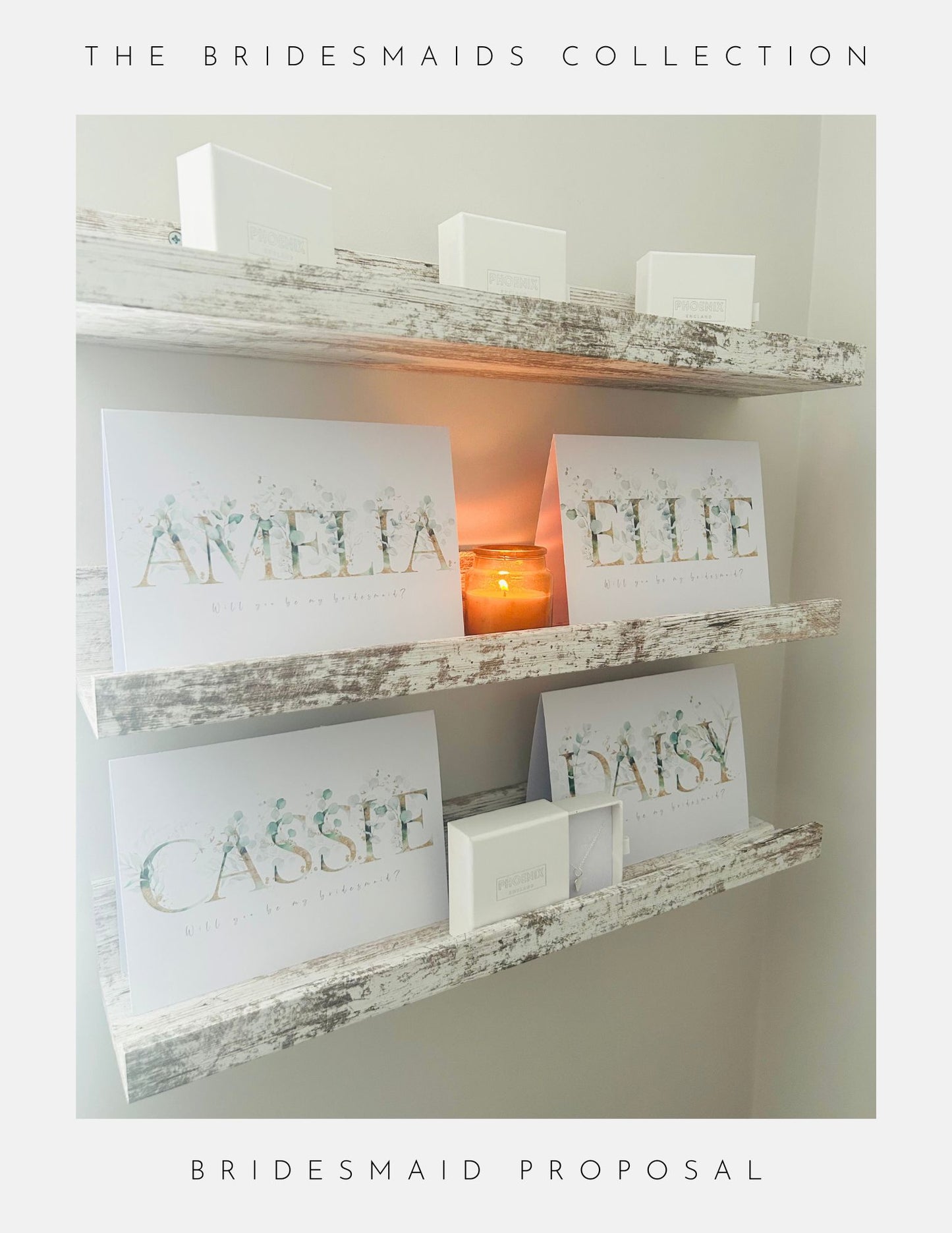 Two rustic white shelves display Phoenix England’s Maid Of Honour Proposal Sterling Silver jewellery with personalized bridesmaid cards labeled Amelia, Ellie, and Cassie, white gift boxes, and a lit candle. Text: “The Bridesmaids Collection” and “Bridesmaid Proposal.”.
