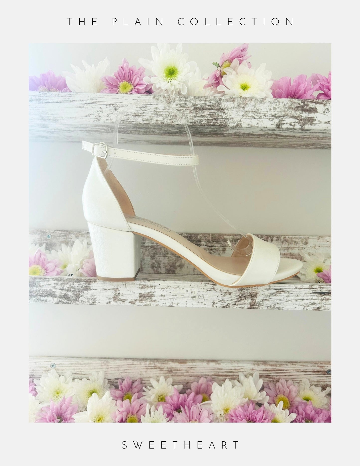 Ivory wedding sandal with block heel on a wooden surface with flowers, labelled 'The Plain Collection' and 'Sweetheart'.