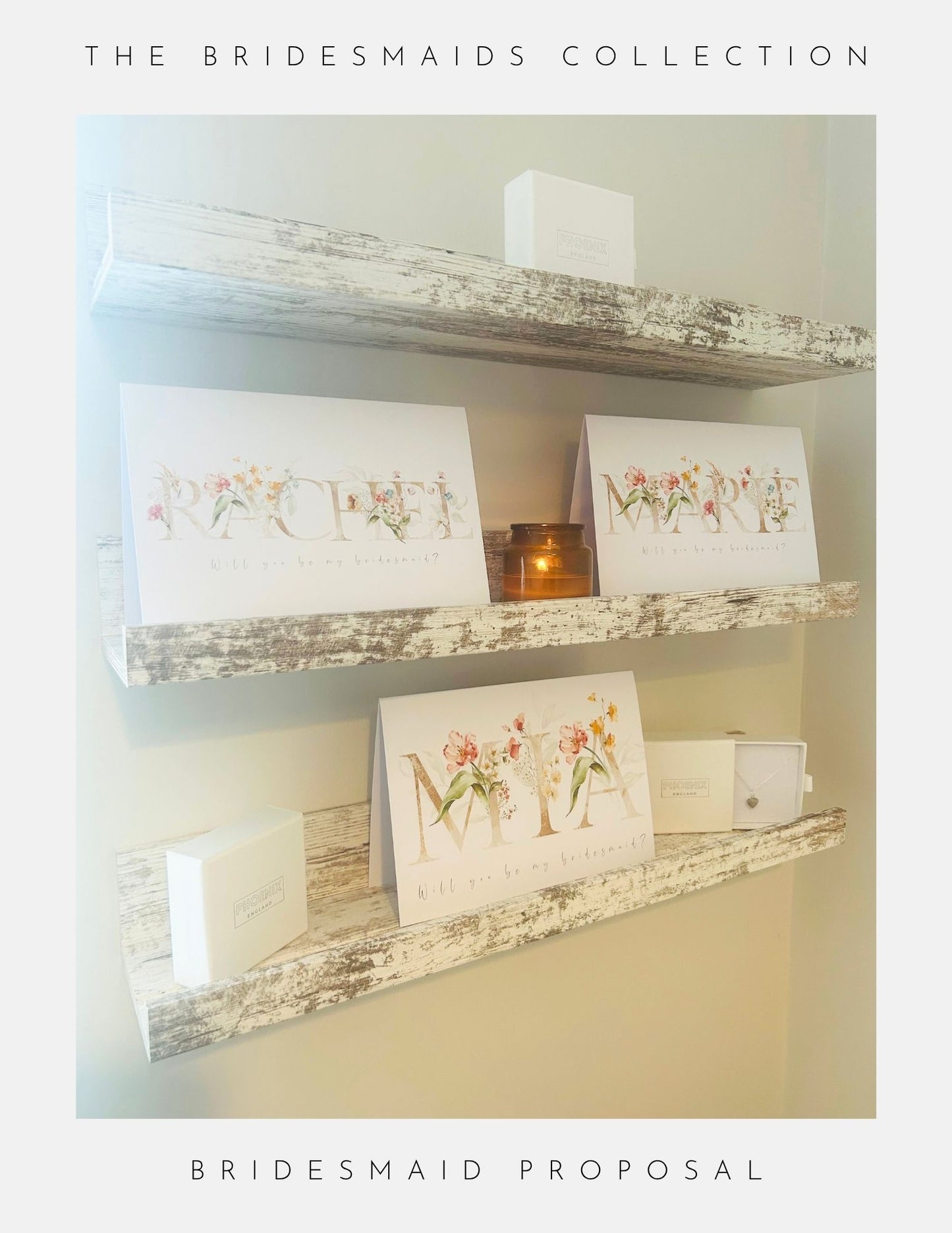 Three rustic white shelves display Phoenix Englands Will You Be My Bridesmaid Gifts featuring floral name cards, sterling silver jewellery boxes, and a candle from The Bridesmaids Collection for your bridesmaid proposal.