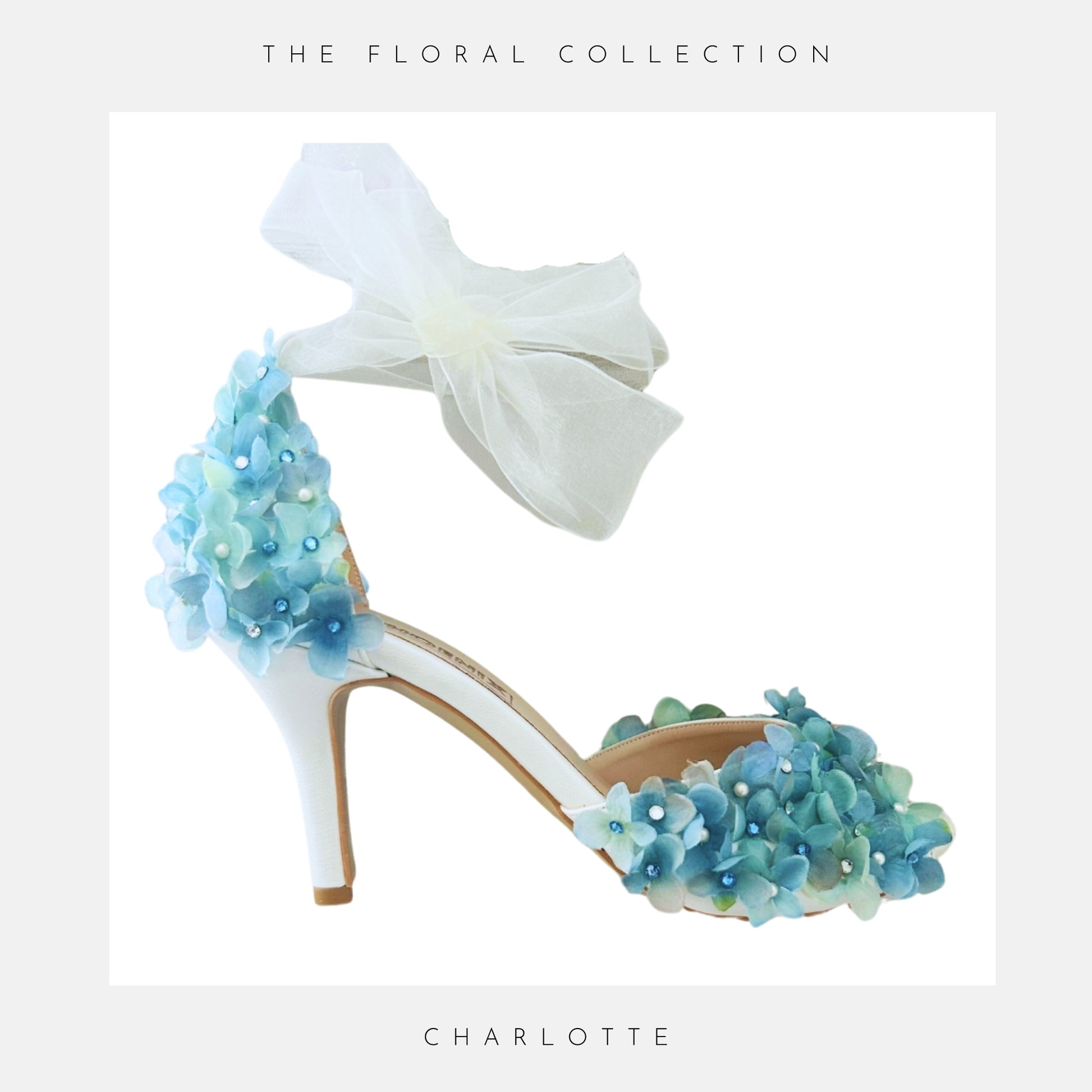 Blue floral high-heeled bridal shoe with blue flowers and organza strap on a white background, labelled 'The Floral Collection' and 'Charlotte'.