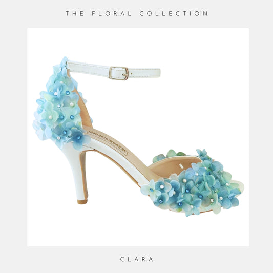 High-heeled peep toe bridal shoe with blue floral design on a white background, labelled 'Clara'.