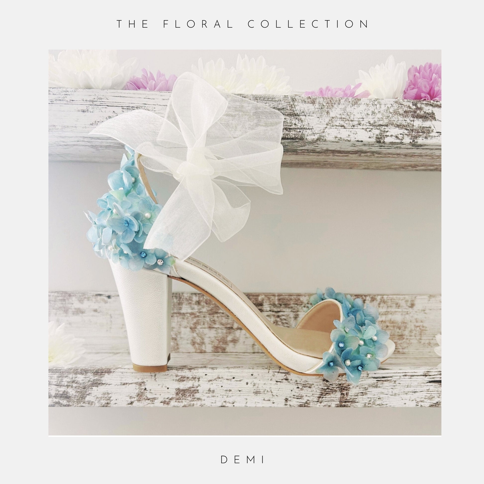 Ivory high-heeled block heel bridal shoes with floral decorations on a wooden surface, labelled 'The Floral Collection' DEMI.