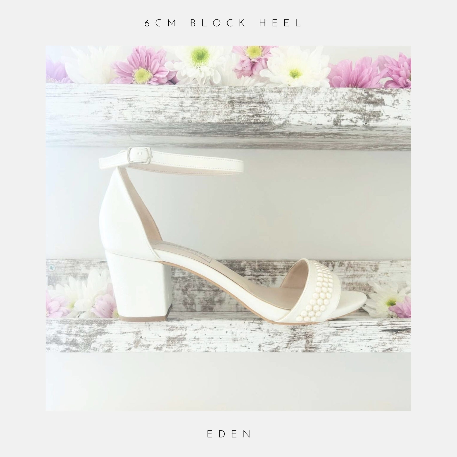 The Eden Pearl Low Block Heel Bridal Shoes by Phoenix England feature elegant pearl accents and an ivory block heel, displayed on a rustic shelf with pink and white flowers. Part of The Pearl Collection, perfect for brides. Text below reads Eden.