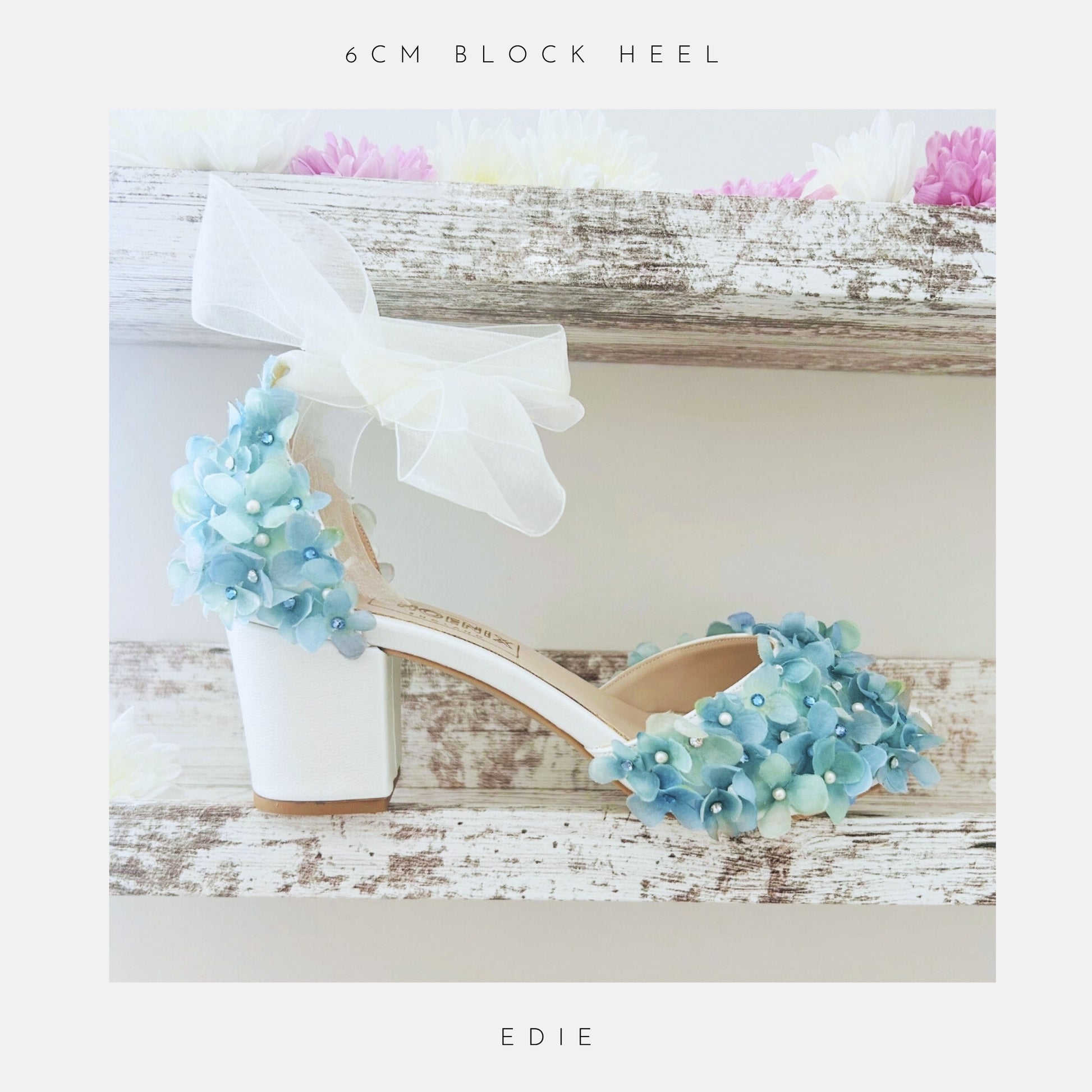 Ivory bridal sandal with blue floral decorations on a wooden surface, labelled '6cm block heel' and 'Edie'.
