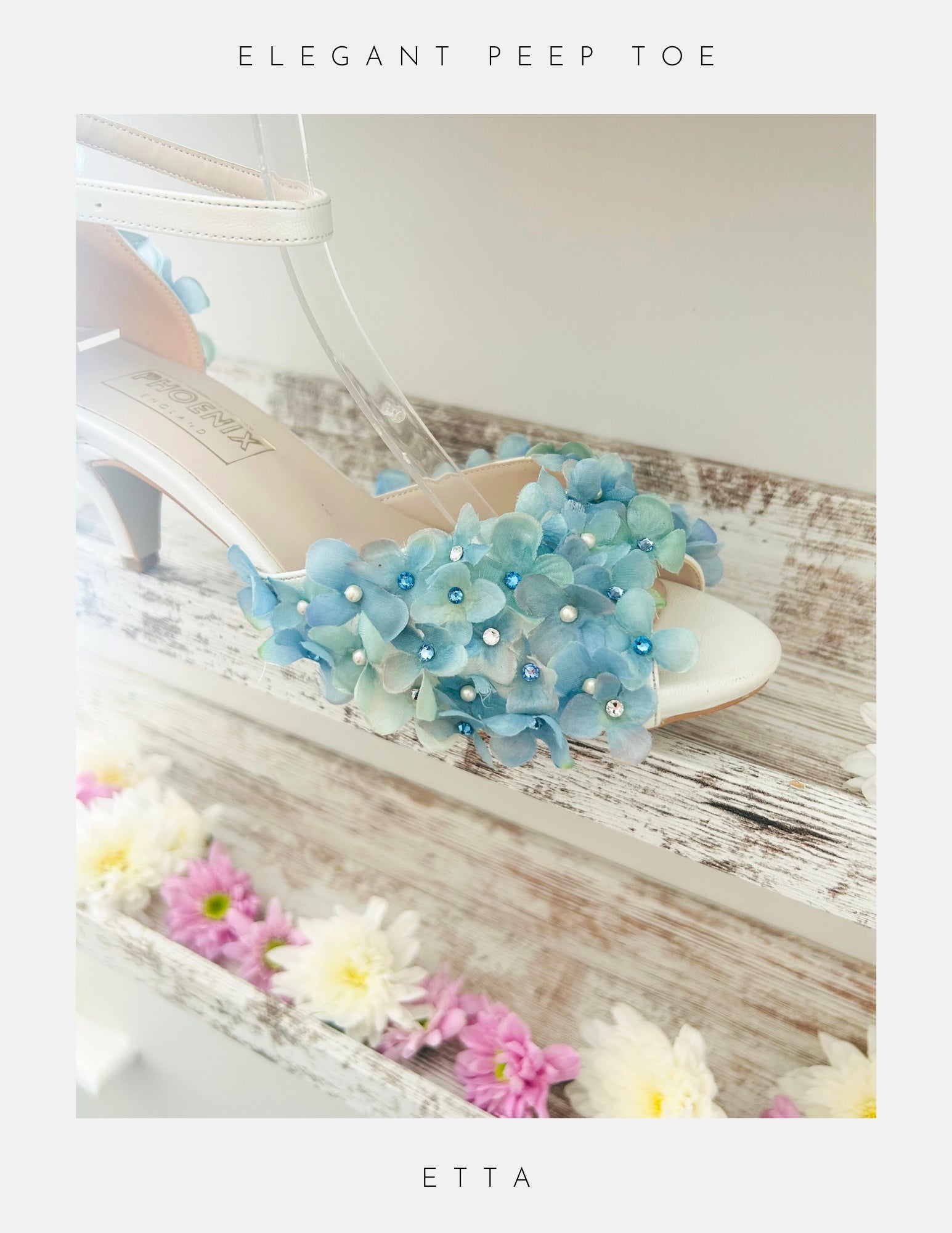 Elegant peep-toe shoe with floral design on a wooden surface with flowers.