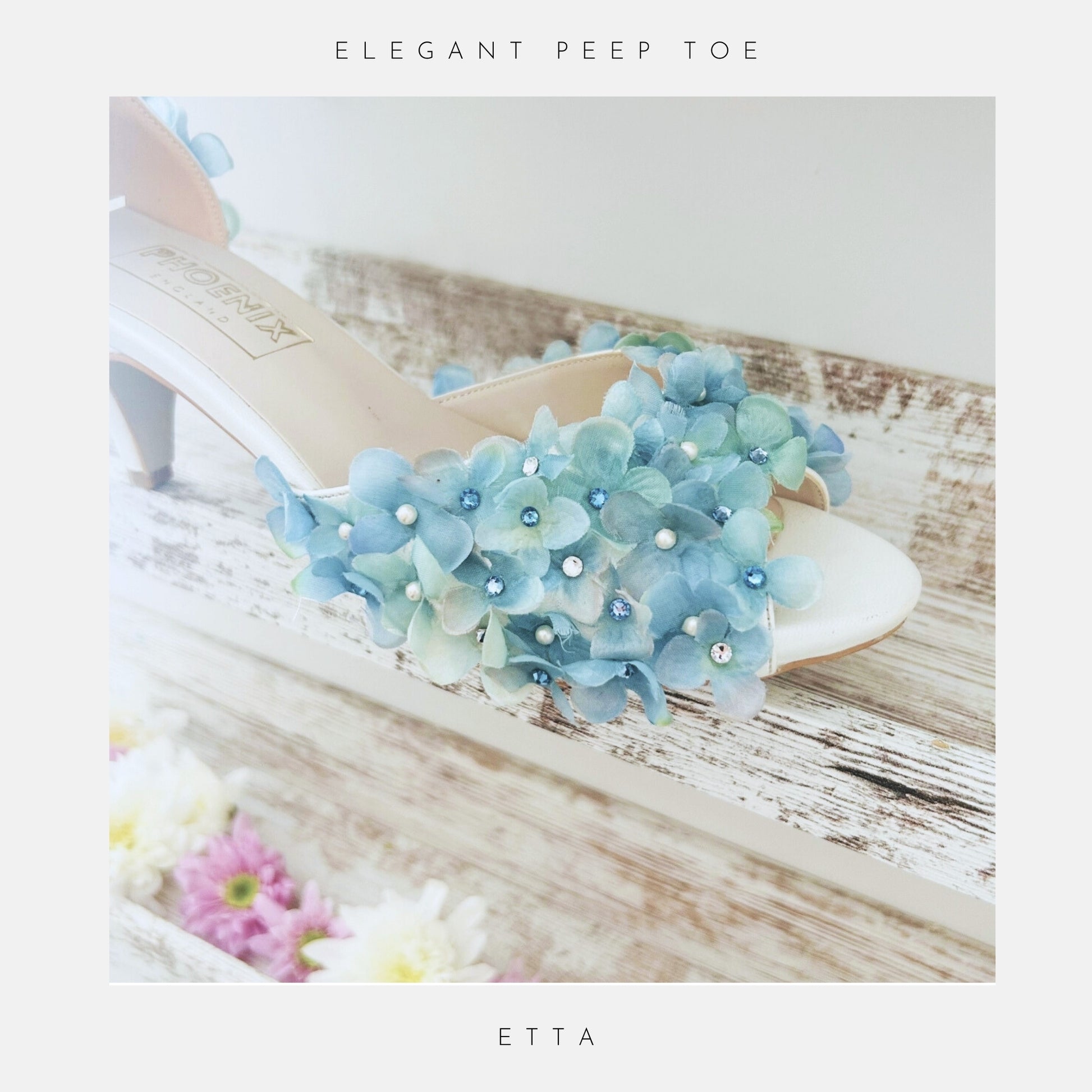 Elegant peep-toe shoe with floral design on a wooden surface with flowers.