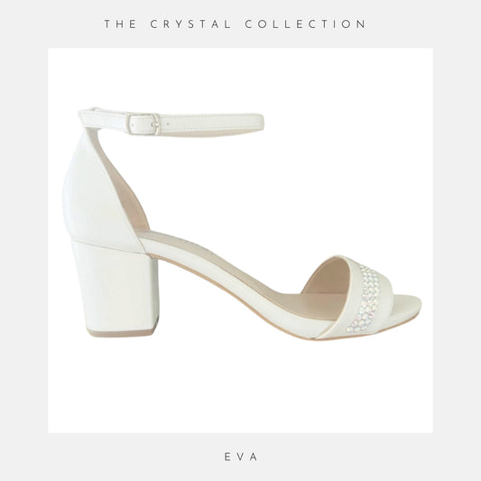 Ivory sandal with block heel and crystal embellishments on a light grey background, labelled 'EVA' from 'The Crystal Collection'.