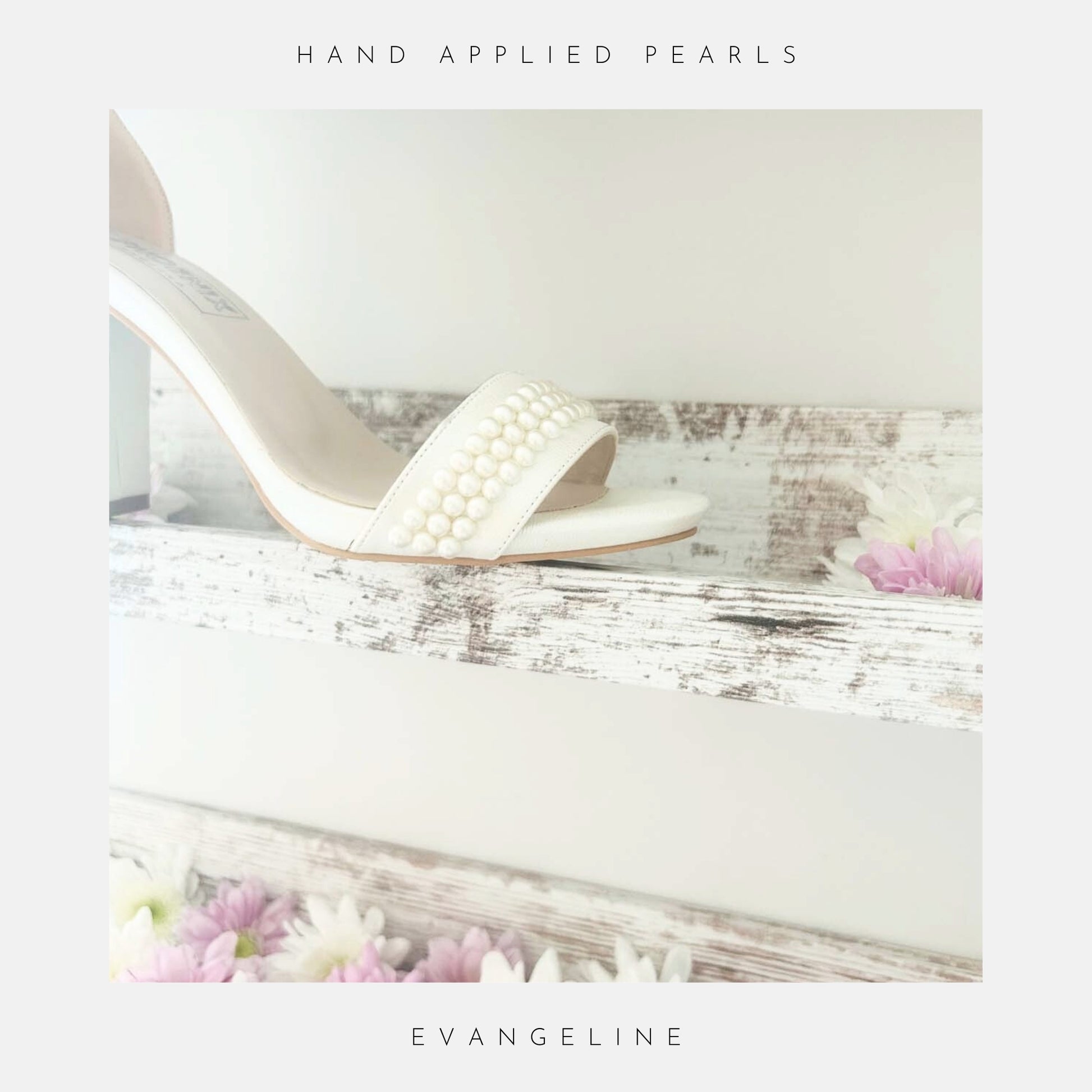 The Evangeline Pearl Block Heel Wedding Shoes by Phoenix England, hand-finished with pearls, are displayed on a rustic wooden shelf among pink and white flowers. The text says Hand Applied Pearls and Evangeline.
