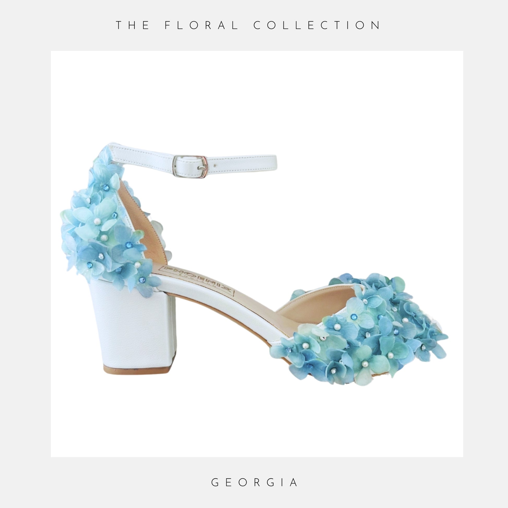 Ivory high-heeled shoe with blue floral embellishments on a white background
