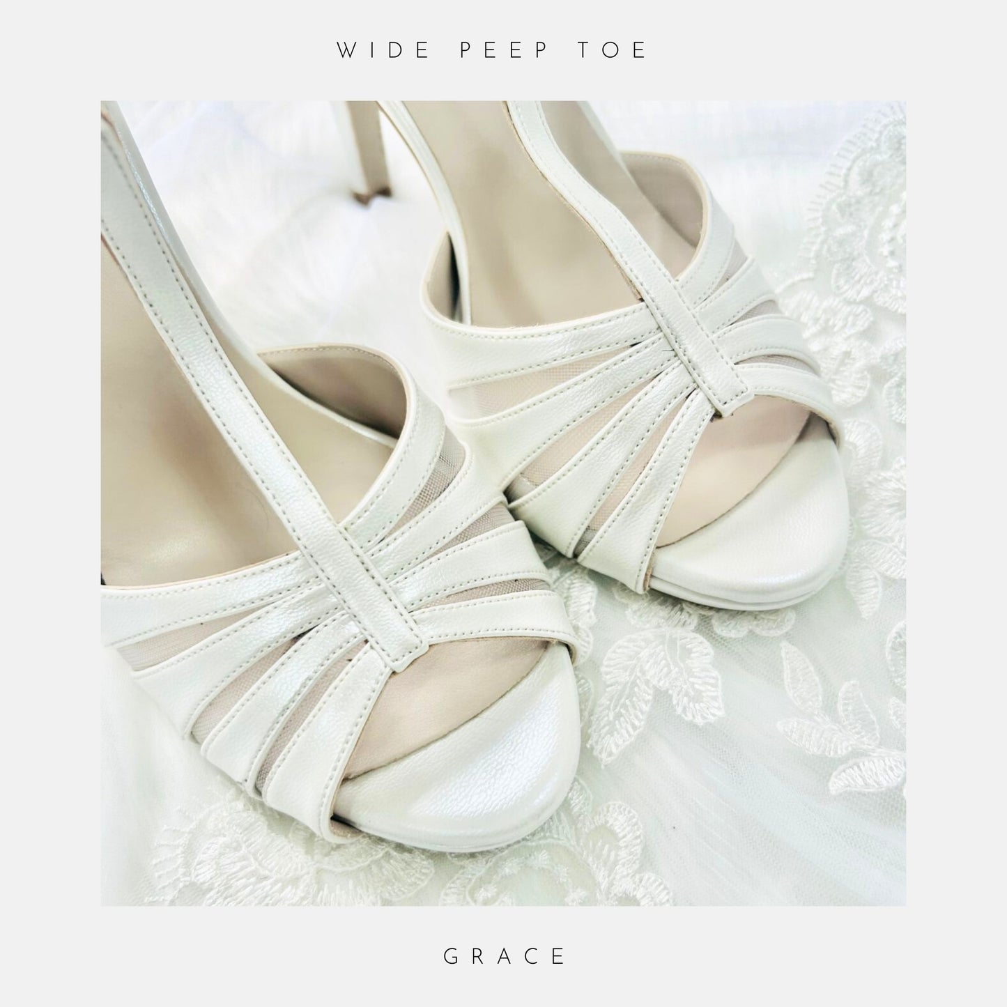 Close-up of Phoenix England’s Grace Vintage Inspired Wedding Shoes in elegant white with wide peep toe and crisscross straps, displayed on delicate lace, perfectly comfortable bridal heels.