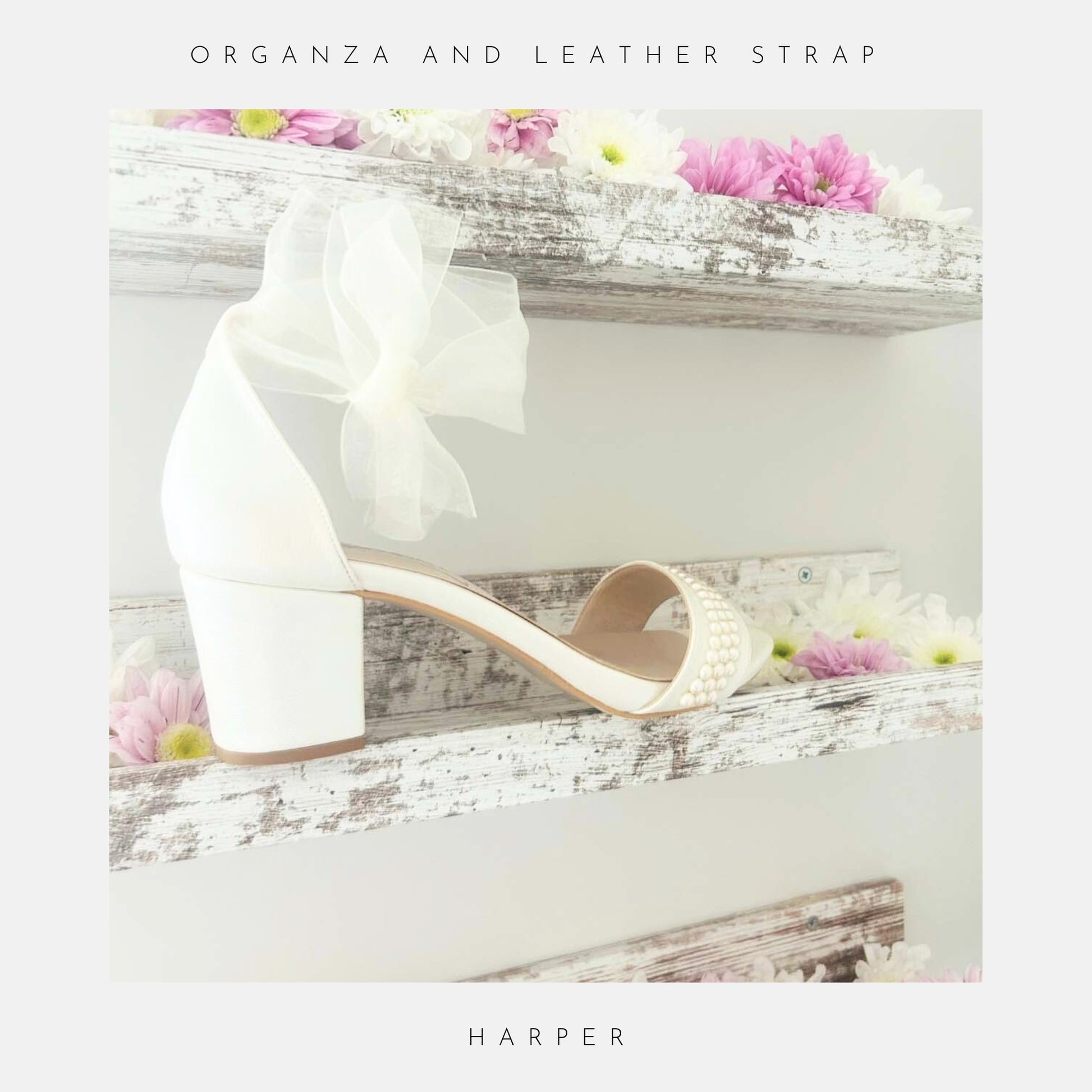 Ivory wedding sandal with an organza bow on a decorative surface with flowers