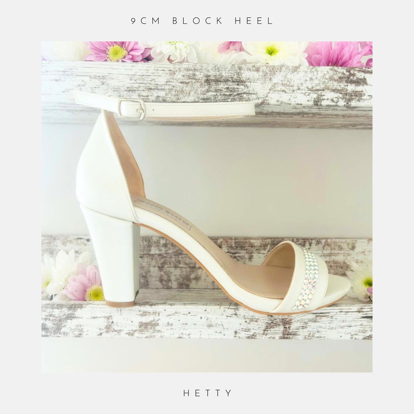 Ivory high-heeled block heel wedding shoe with crystal embellishments on a decorative background with flowers.