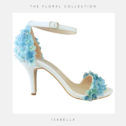 Pretty open toe high heel bridal shoe on a white background and finished with blue flowers.
