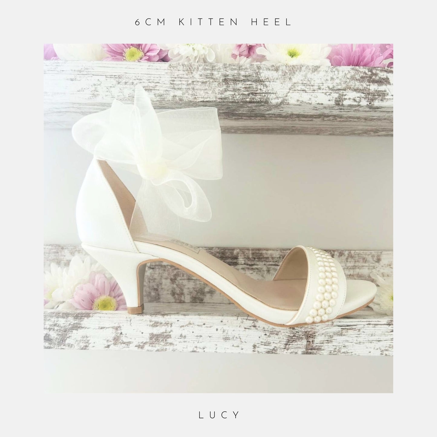 Ivory open toe pearl bridal sandal with pearls on a wooden surface with flowers, labelled '6cm kitten heel' and 'Lucy'.