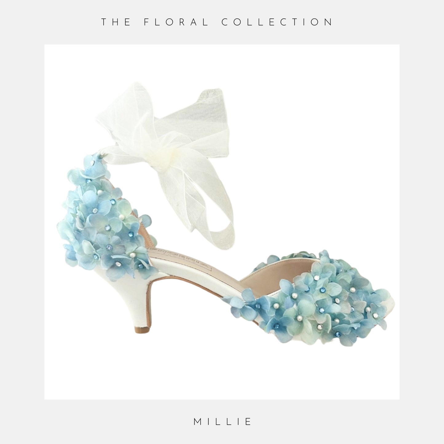 Ivory high-heeled shoes with blue floral decorations and a white bow, labelled 'The Floral Collection' and 'Millie'.