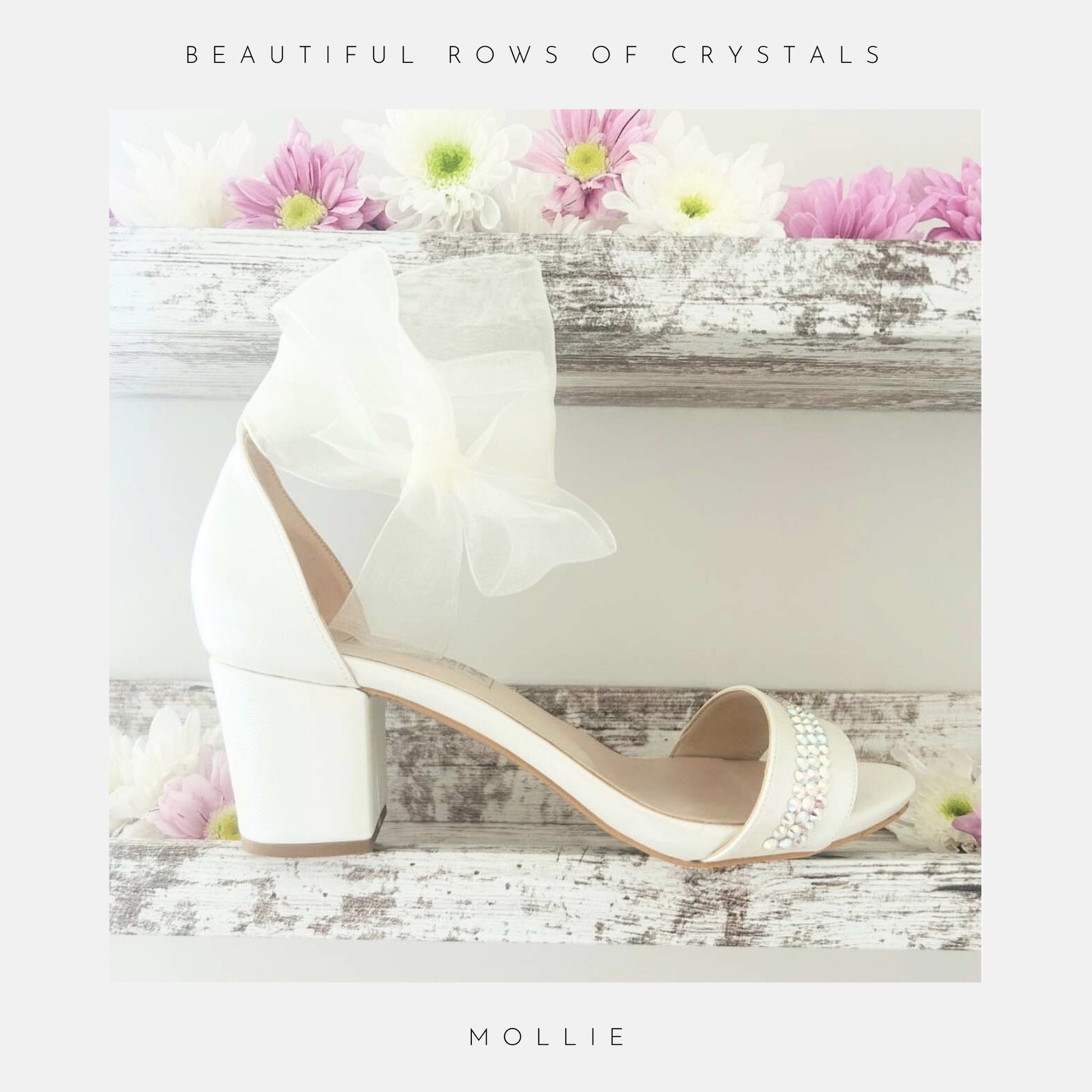 Ivory bridal sandal with block heel organza bow and crystals on a wooden surface with flowers, labelled 'Beautiful Rows Of Crystals' and 'Mollie'.