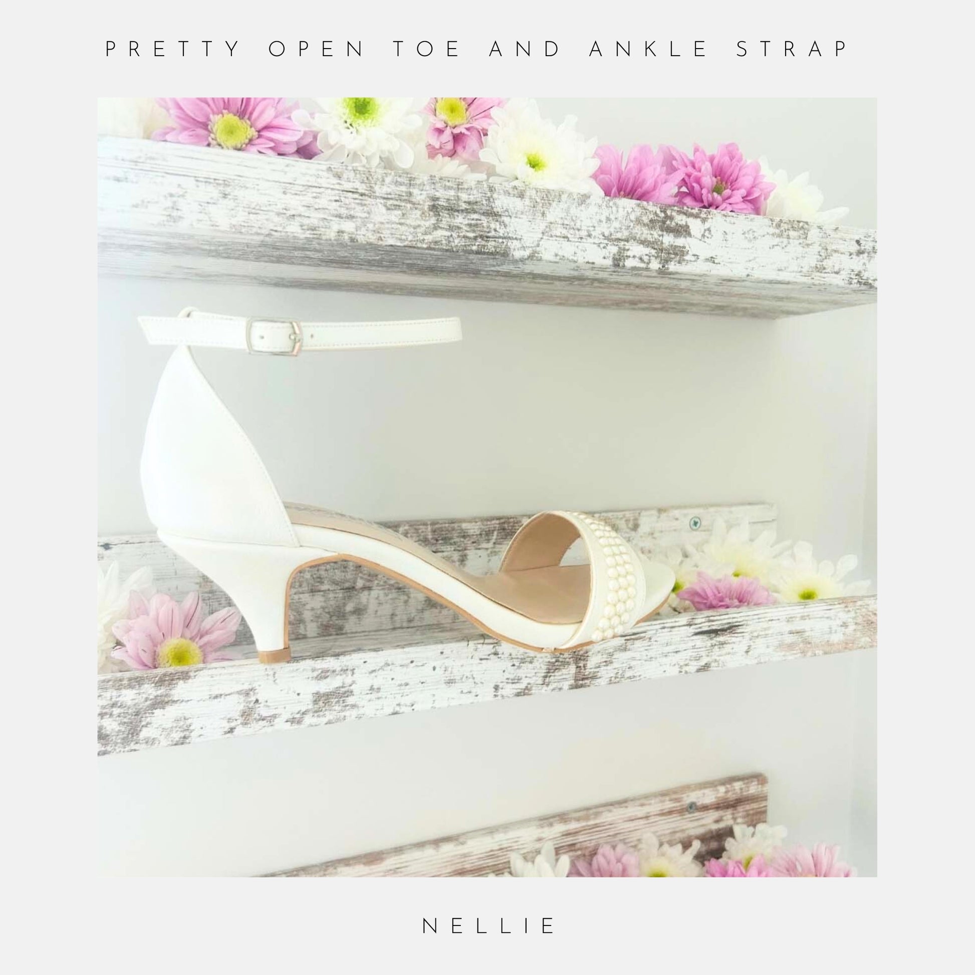 The Phoenix England Nellie Pearl Kitten Heel Bridal Shoes in ivory pearl are shown on a rustic wooden shelf with pink and white flowers. Text reads Pretty Open Toe And Ankle Strap above and Nellie below, perfect for brides.