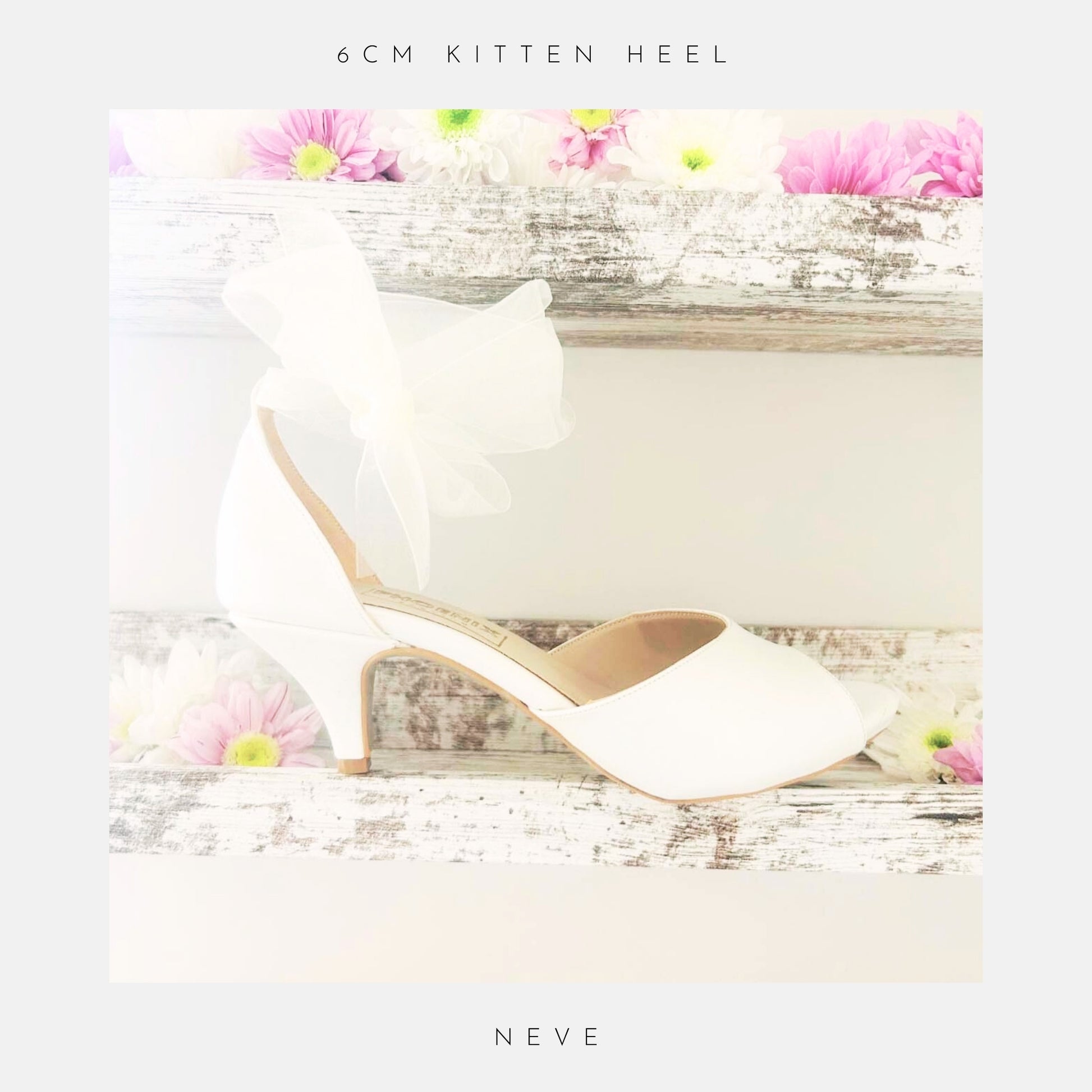 Ivory peep toe wedding shoe with an organza bow and kitten heel on a wooden surface with flowers, labelled 'The Organza Collection'.