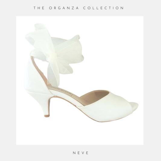 A peep toe bridal shoe with kitten heel and organza ankle strap with the words The Organza Collection and Neve