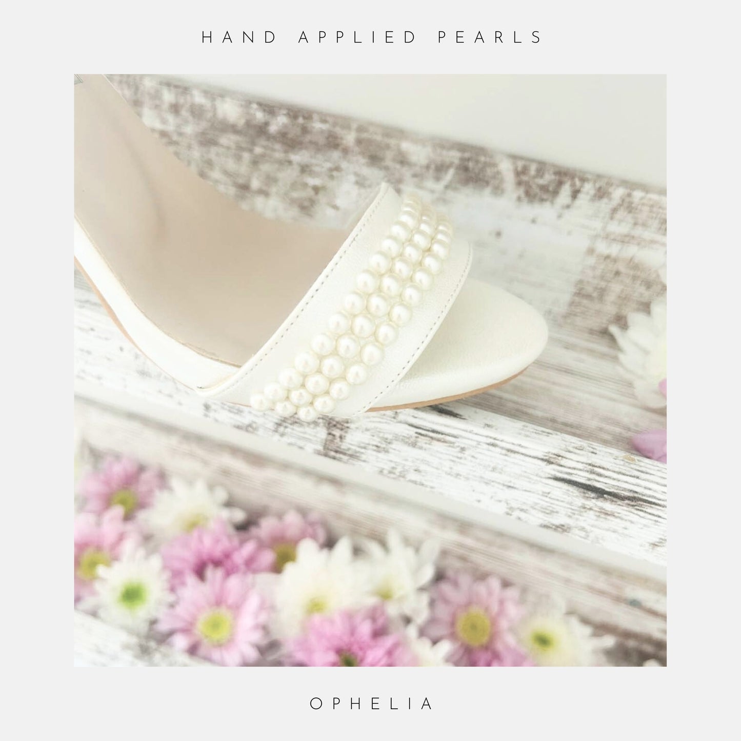 The Ophelia Pearl High Heel Wedding Shoes by Phoenix England, hand-finished with crystal pearls, rest on rustic wood amidst pink and white daisies. Perfect bridal heels for your big day.