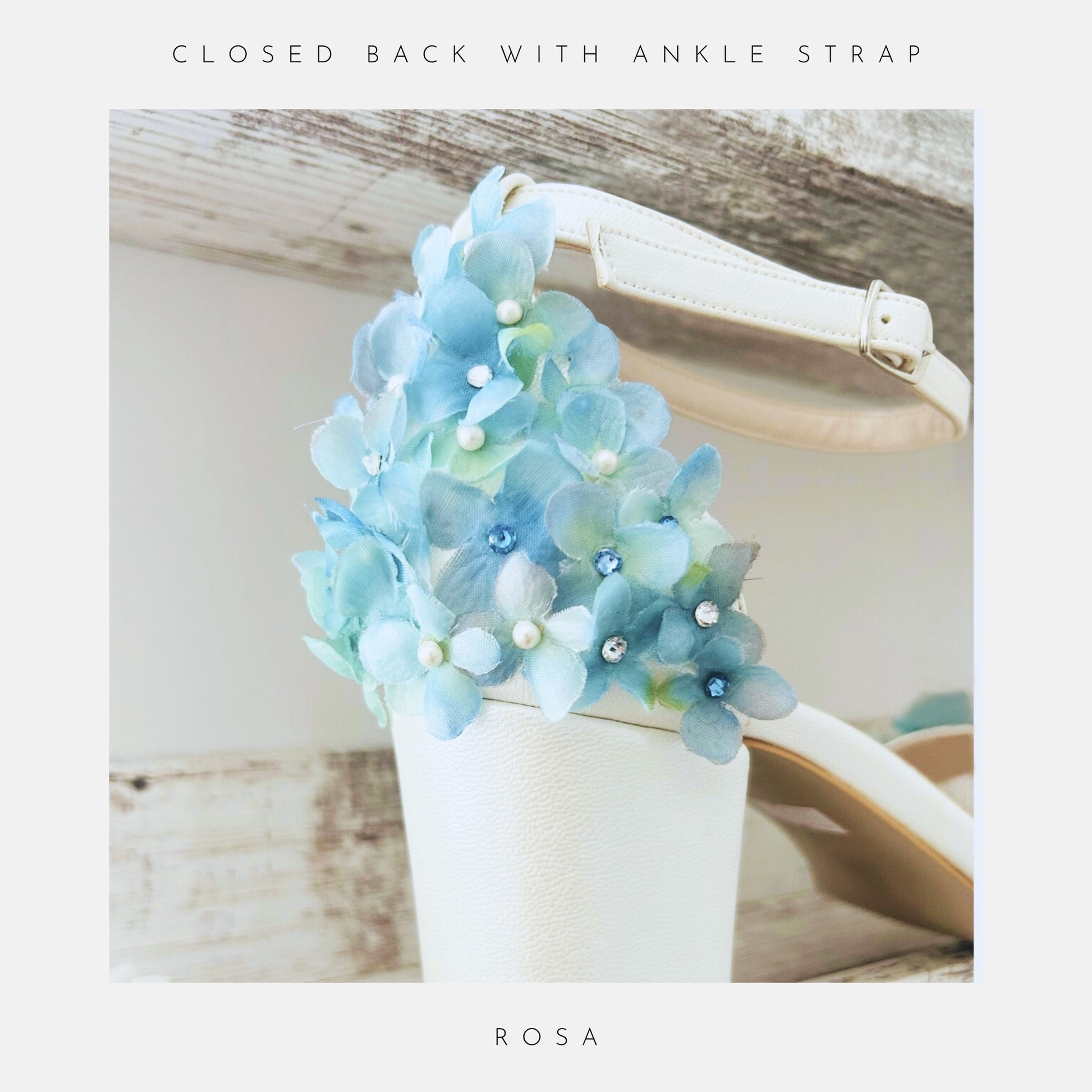 The Rosa Floral Low Block Heel Bridal Shoes by Phoenix England feature an ivory design with ankle strap, blue and light green floral details, Austrian crystals, and pearl embellishments on the heel. Text: Austrian Crystals & Pearls and ROSA.