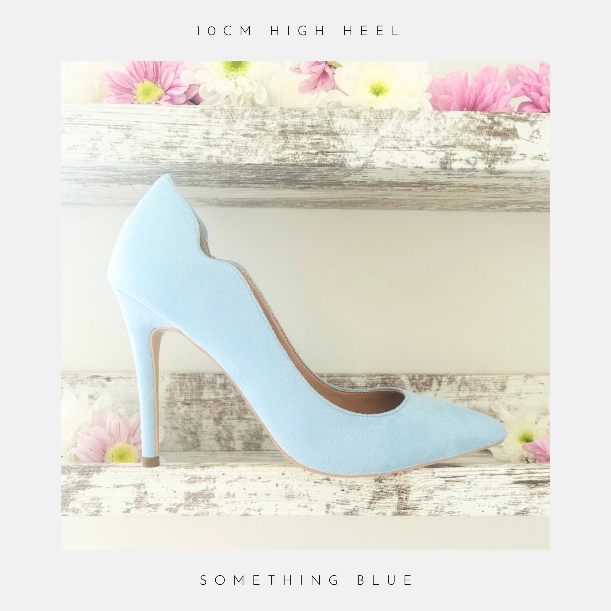 Blue faux suede high-heeled bridal shoe on a decorative wooden shelf with flowers.